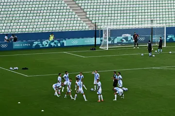 The Argentina players came back out to warm up in an empty stadium before their match against Morocco was completed following a two-hour interruption