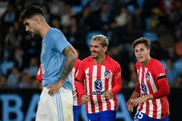 Atletico Madrid's French forward Antoine Griezmann (C) celebrates with team-mates after completing his hat-trick against Celta