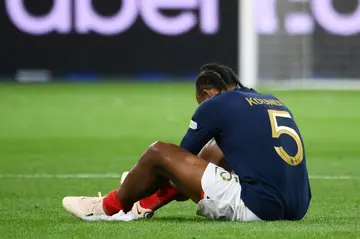 Jules Kounde sits on the pitch after injuring his thigh  playing for France against Austria