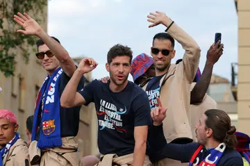 Barca players Robert Lewandowski (L), Sergi Roberto (C) and Sergio Busquets (R) celebrate on top of their bus