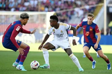 Vinicius Junior (C) takes on Barcelona defender Ronald Araujo (L) in Real Madrid's 2-1 Clasico victory over the Catalan side