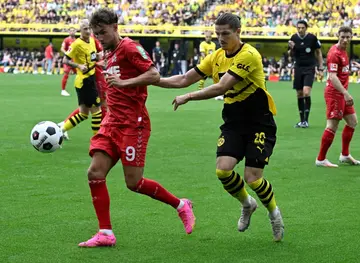 Dortmund midfielder Marcel Sabitzer (R) and Cologne forward Luca Waldschmid vie for the ball.