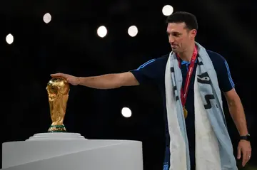 Argentina's coach Lionel Scaloni touches the World Cup trophy