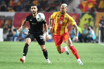 Karim Fouad (L) of Al Ahly and Yan Sasse of Esperance battle for possession during first leg of 2024 CAF Champions League final in Tunisia.