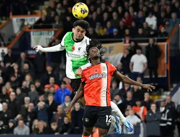 Luis Diaz (L) heads in Liverpool's injury-time equaliser at Luton