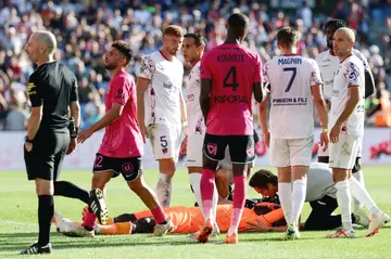 Clermont goalkeeper Mory Diaw (C) lies on the ground after a firecracker exploded next to him during his side's Ligue 1 game at Montpellier