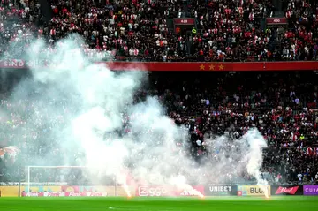 Smoked out: Flares are thrown onto the pitch as the game between Ajax and Feyenoord was abandoned