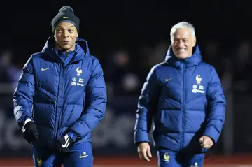 France forward Kylian Mbappe (left) and coach Didier Deschamps attend a training session
