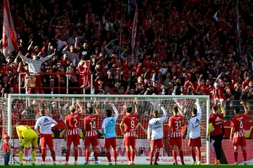Union Berlin players celebrate with their fans after beating Wolfsburg to stay top of the Bundesliga