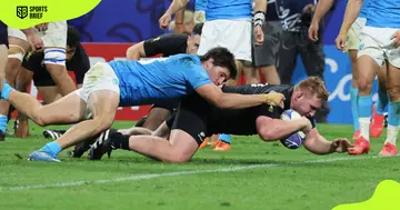 New Zealand's Fletcher Newell (in black) scores a try.