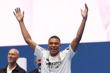 Kylian Mbappe salutes the Real Madrid fans as a former French hero at the club, Zinedine Zidane, looks on