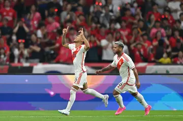 Peru's Bryan Reyna (L) celebrates after scoring in a friendly against South Korea