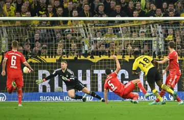 Dortmund's German forward Youssoufa Moukoko (2nd R) scores against Bayern Munich