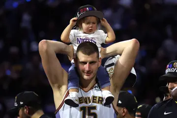 Nikola Jokić with his daughter in matching white Denver Nuggets outfits