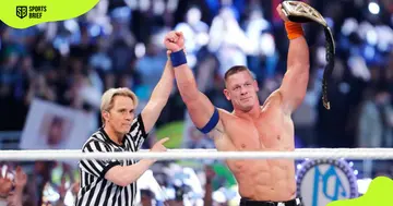 John Cena (l) lifts the WWE Championship belt.