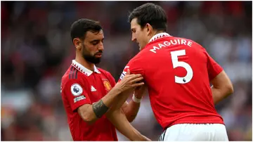 Bruno Fernandes gives the captain's armband to Harry Maguire during the Premier League match between Manchester United and Arsenal FC at Old Trafford. Photo by Shaun Botterill.