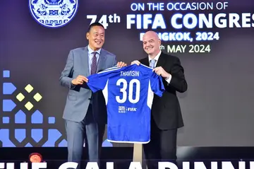 Thailand Prime Minister Srettha Thavisin is given a shirt by FIFA presidemt Gianni Infantino at a gala dinner ahead of the FIFA Congress in Bangkok