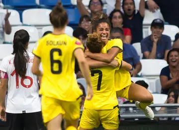 Jamaica's Kalyssa van Zanten, at right facing the camera, celebrates with teammates after scoring the winning goal against Costa Rica in the third-place match at the CONCACAF W Championship