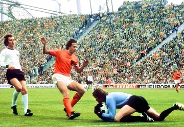 West Germany goalkeeper Sepp Maier catches the ball in front of Dutch forward Johan Cruyff as defender Franz Beckenbauer looks on at the 1974 World Cup final in Munich