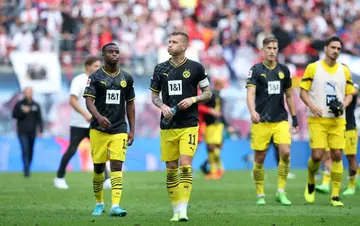 Dortmund forward Marco Reus leads his disappointed side off the pitch