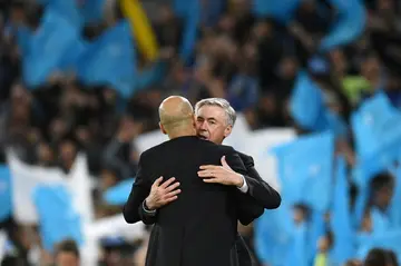 Real Madrid's Italian coach Carlo Ancelotti (R) congratulates Manchester City's Spanish manager Pep Guardiola