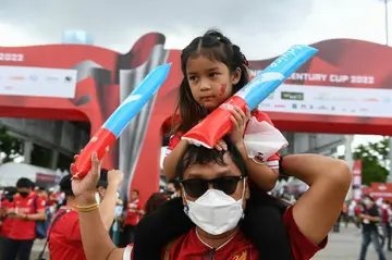 Liverpool fans revels in a fan zone area outside Rajamangala National Stadium ahead of the match against Manchester United