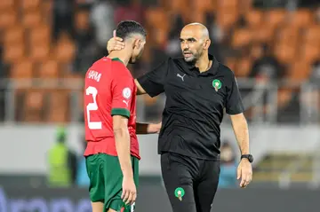 Achraf Hakimi is comforted by coach Walid Regragui after Morocco were knocked out of the Cup of Nations on Tuesday