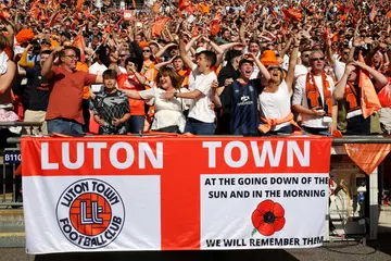 Luton Town supporters celebrate behind a flag during the Championship play-off match between Coventry City and Luton Town at Wembley Stadium on May 27, 2023