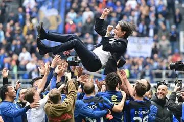 Inter Milan players celebrate the Serie A trophy by tossing coach Simone Inzaghi into the air