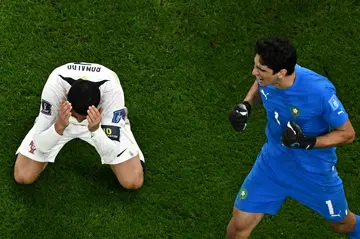 Cristiano Ronaldo (L) with his head in his hands after being denied by Morocco's Yassine Bounou (R)