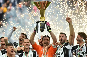 Gianluigi Buffon holds the 2015-2016 Serie A trophy aloft surrounded by his Juventus teammates