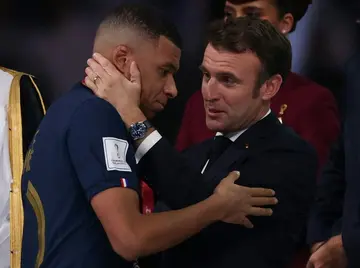 Macron consoles Kylian Mbappe as the striker receives hands the FIFA Golden Boot award