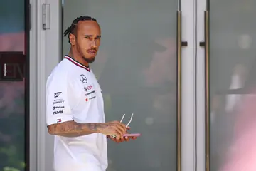 Lewis Hamilton looks on in the Paddock