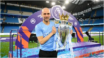 Pep Guardiola celebrates with the Premier League trophy at Etihad Stadium. Photo by Michael Regan.