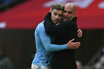 Manchester City manager Pep Guardiola embraces Jack Grealish