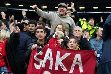 Arsenal fans celebrate during the Premier League match at the London Stadium on February 11, 2024