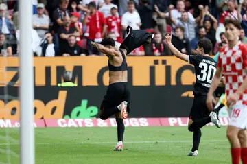 Frankfurt forward Omar Marmoush removes his shirt after scoring a late equaliser away at Mainz