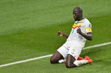 Kalidou Koulibaly celebrates scoring his team's second goal against Ecuador, wearing an armband bearing the number 19 of late Senegal player Papa Bouba Diop