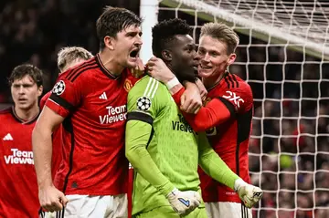 Manchester United's goal-scorer Harry Maguire (L) celebrates with Andre Onana after the goalkeeper's late penalty save against FC Copenhagen