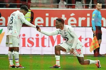 Jonathan David (R) celebrates with Angel Gomes after scoring against Reims