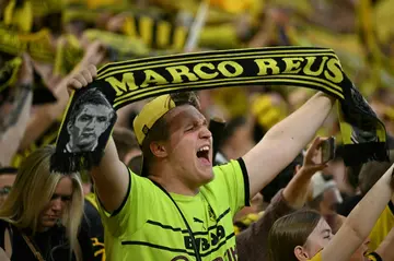 A Dortmund fan displays a Marco Reus scarf while singing "You'll Never Walk Alone" before the club's home clash with PSG on Wednesday