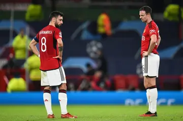 Bruno Fernandes and Jonny Evans look on after Manchester United were eliminated from the Champions League