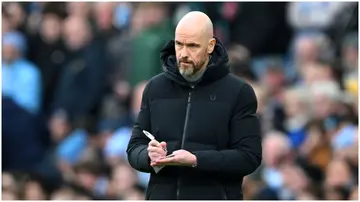 Erik ten Hag looks on as he takes notes during the Premier League match between Manchester City and Manchester United at Etihad Stadium. Photo by Michael Regan.