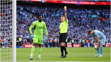Referee Robert Jones shows a yellow card to Andre Onana in the penalty shootout during the Emirates FA Cup semi-final match between Coventry City and Manchester United. Photo by Richard Heathcote.