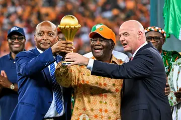 CAF president Patrice Motsepe (L), President Alassane Ouattara of the Ivory Coast and FIFA president Gianni Infantino hold the Africa Cup of Nations trophy after hosts Ivory Coast won the 2024 final.