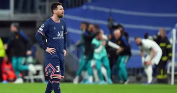 Lionel Messi cuts a dejected figure as Karim Benzema celebrates their side's third goal during the UEFA Champions League Round Of Sixteen. (Photo by Angel Martinez/Getty Images)