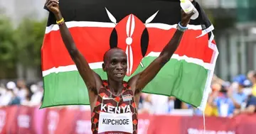 Eliud Kipchoge celebrates with the Kenyan national flag after winning the men's marathon at the Tokyo Olympics on Aug. 8, 2021, in Sapporo, northern Japan. (Photo by Kyodo News via Getty Images)