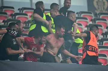 Fans fight with stadium stewards after violent clashes between FC Cologne and Nice supporters erupted ahead of the UEFA Europa Conference League football match at the Allianz Riviera in Nice