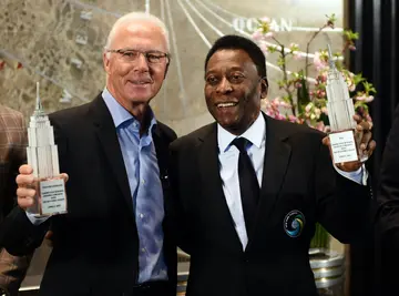 New York Cosmos soccer legends Pele (right) and Franz Beckenbauer pose after they "flip the switch" at the  Empire State Building April 17, 2015 in New York to launch the start of the teams 2015 spring season.