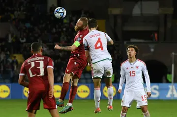 Armenia's Varazdat Haroyan (C-L) and Wales' Ben Davies (C-R) contest the ball during the Euro 2024 qualifier between their two sides